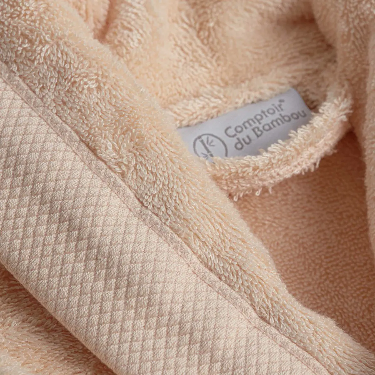 Détail col et étiquette peignoir Palace pêche Comptoir du Bambou Détail col et étiquette peignoir éponge col châle couleur pêche collection palace en viscose de bambou