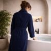 Peignoir bleu nuit présenté dans une salle de bain haut de gamme