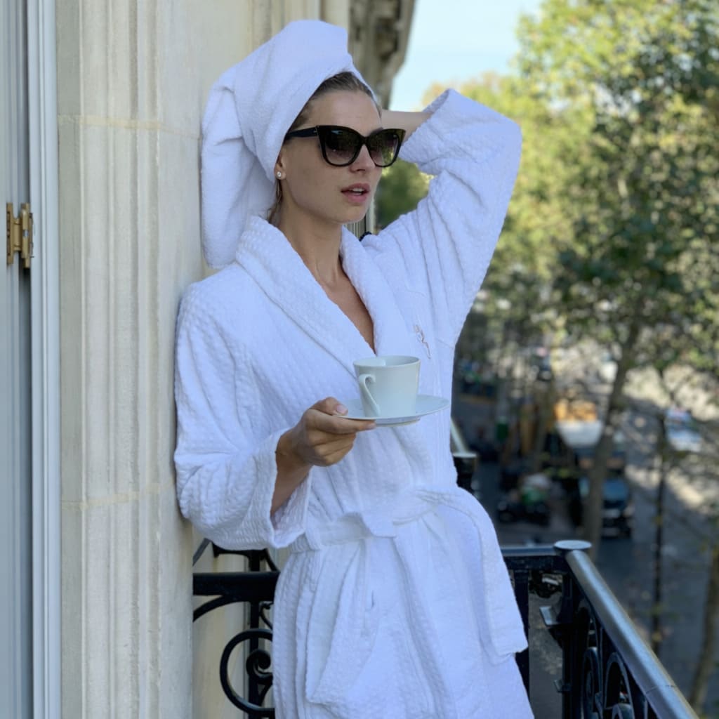 Peignoir blanc texturé style hôtel de luxe à Paris, atmosphère chic et raffinée.
