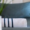 Serviettes en bambou haut de gamme, prêtes à offrir douceur et confort, méticuleusement disposées sur le lit d'une chambre d'hôtel, pour une expérience de séjour des plus agréables.