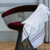 Serviette en bambou délicatement disposée sur une chaise design, ajoutant une touche de confort et de sophistication à l'atmosphère d'une pièce haut de gamme