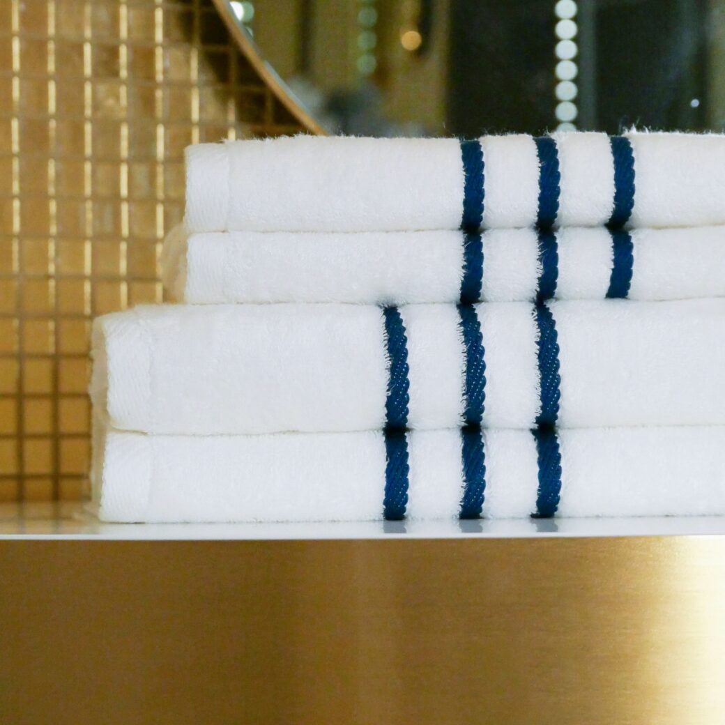 Image détaillée de serviettes en bambou finement pliées, déposées sur une table, créant une ambiance accueillante et luxueuse dans cet espace.