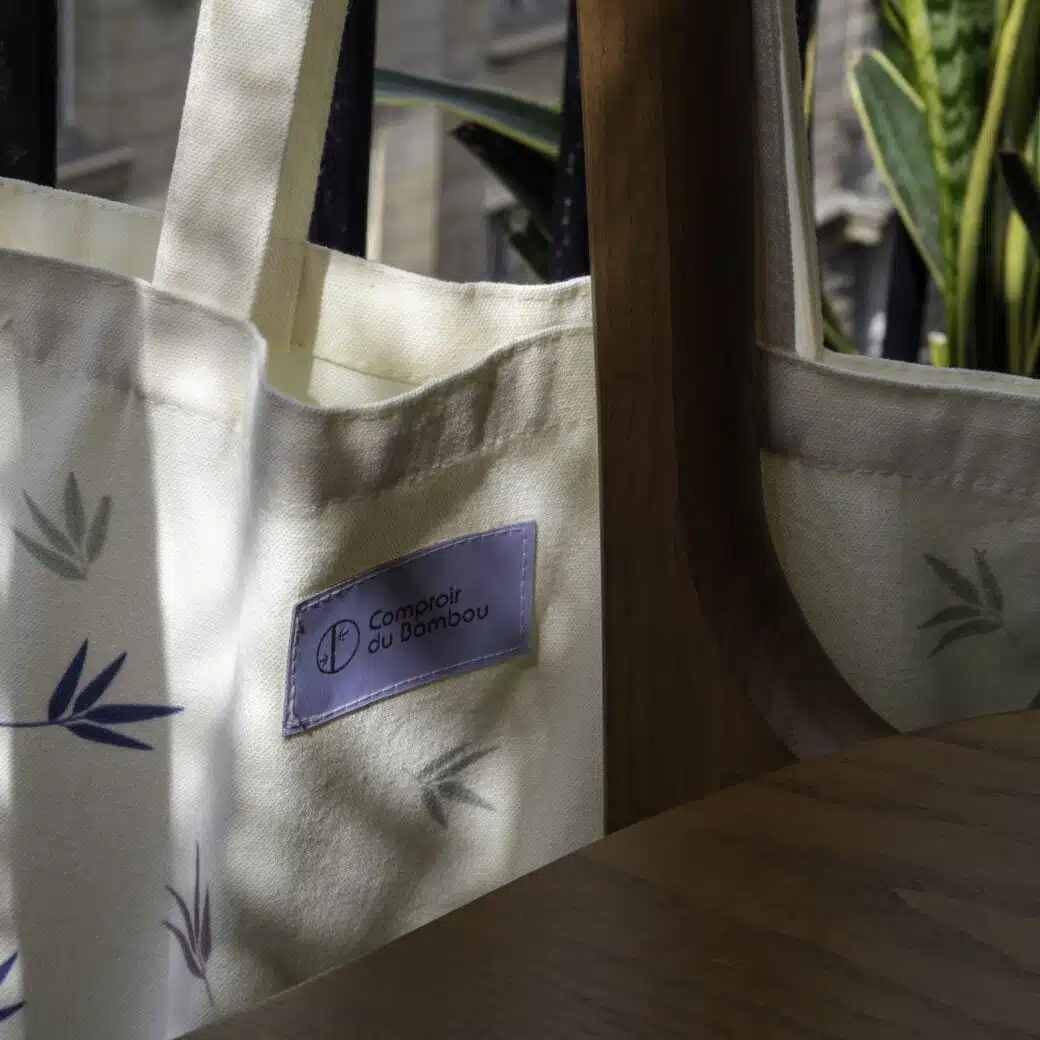 Un tote bag élégamment présenté avec une variété d'accessoires soigneusement disposés à l'intérieur, prêt à vous accompagner lors de vos aventures quotidiennes. Des lunettes de soleil, une bouteille d'eau, un carnet et un porte-monnaie se nichent confortablement dans le sac, offrant à la fois praticité et style pour une journée bien remplie à l'extérieur. Ce tote bag polyvalent est l'accessoire parfait pour toutes vos escapades, qu'elles soient en ville, à la plage ou en voyage.