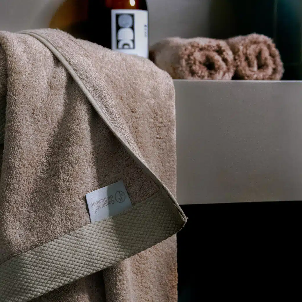 Dans ce sanctuaire de détente, une serviette en pulpe de bois et fibre de bambou repose gracieusement sur un banc en bois, capturant l'essence du luxe et de la nature. Son toucher doux et sa couleur apaisante complètent l'ambiance apaisante de la salle de bain, offrant une expérience sensorielle indulgente. Avec son engagement envers la durabilité, cette serviette incarne l'harmonie entre le confort, le style et le respect de l'environnement, ajoutant une touche de sophistication à ce havre de bien-être.