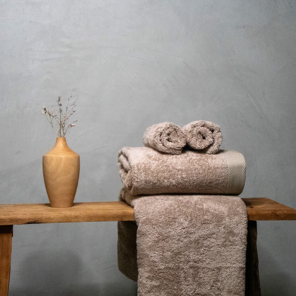 R- P1013227 Une serviette en pulpe de bois et fibre de bambou, élégamment disposée sur un banc en bois, ajoute une touche de luxe et de durabilité à cette salle de bain somptueuse. Son aspect naturel et sa texture douce offrent une expérience de confort inégalée, tandis que son engagement écologique ravive l'esprit de bien-être et de respect de l'environnement.